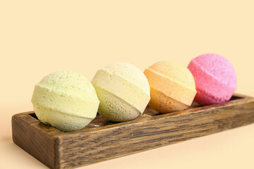 Stand with bath bombs on beige background, closeup