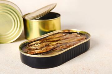 Opened tin cans with sprats in oil on light table