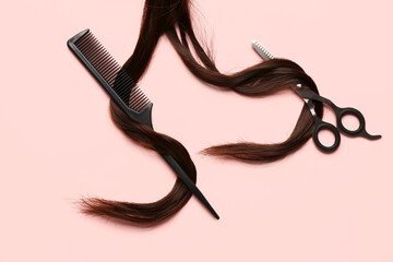 Brown hair with scissors and brush on pink background