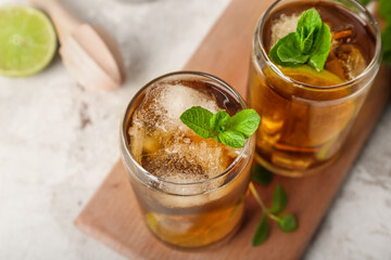 Glasses of tasty Cuba Libre cocktail on light background, closeup
