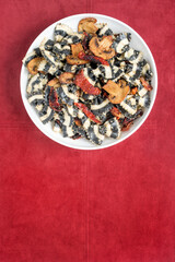 Bowl of Black and White Pasta on Rust Suede Background, Vertical