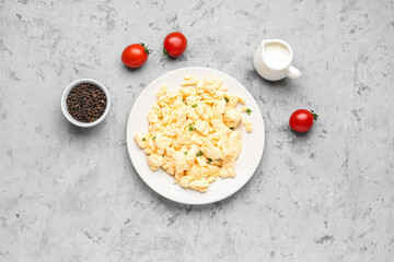 Plate of scrambled eggs with peppercorns on grunge background