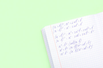 Copybook with maths formulas on green background