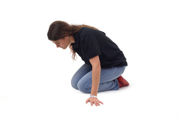  side view a young girl who is on her knees on the floor looking for something on a white background
