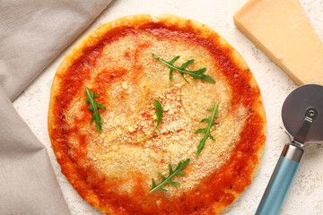 Tasty pizza with parmesan cheese and cutter on light background