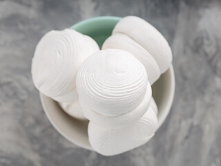 Marshmallows in bowl on a gray background. Sweet dessert zephyr marshmallows on concrete. Close up