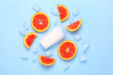 Deodorant with grapefruit slices on blue background
