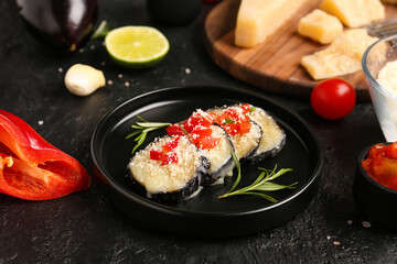 Plate with tasty baked Eggplant Parmesan on dark background