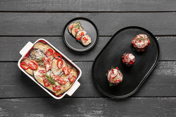 Tasty baked Eggplant Parmesan on dark wooden background