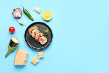 Plate with tasty baked Eggplant Parmesan and ingredients on blue background