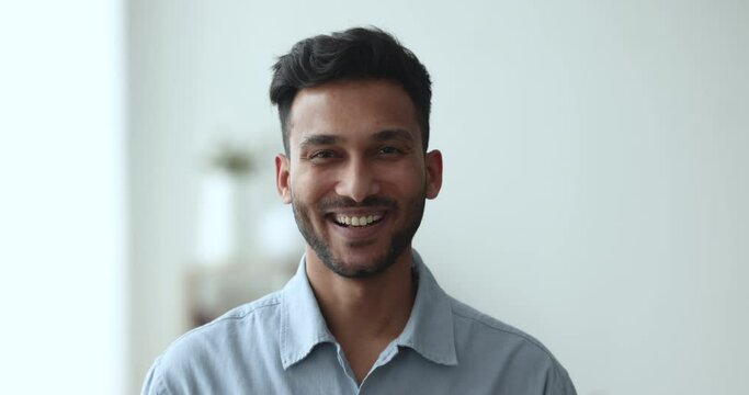 Head shot handsome positive Indian man poses indoor. Millennial bearded guy with attractive appearance, wide toothed smile look at camera, tenant or homeowner, professional occupation Generative AI