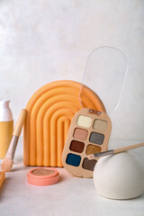 Decorative plaster podiums and cosmetics on light background