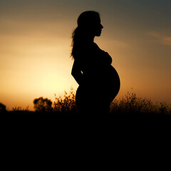 Pregnant woman silhouette with sunset background