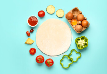 Raw dough and ingredients for preparing vegetable pie on blue background