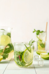 Glass of tasty mojito on table
