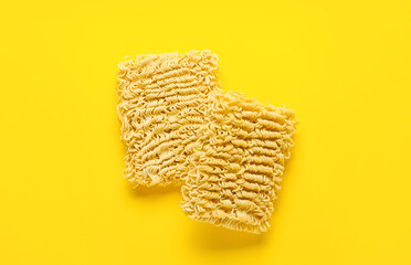 Raw instant noodles on yellow background