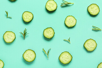 Slices of cucumber with rosemary on turquoise background