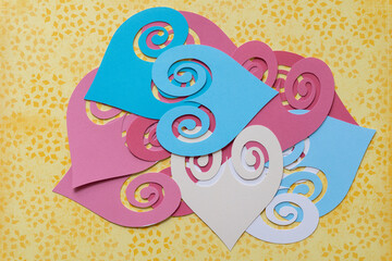 pile of ornamental heart shape cutouts on yellow scrapbook paper