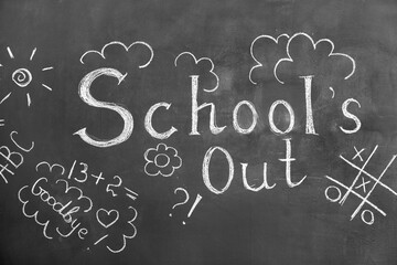 Fototapeta na wymiar Text SCHOOL'S OUT with drawings on blackboard