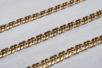 Gold chain necklace on grey, closeup.Gold chain details.