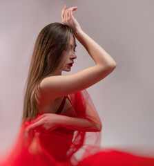 Obraz premium sexy girl with red transparent fabric on a white background copy paste