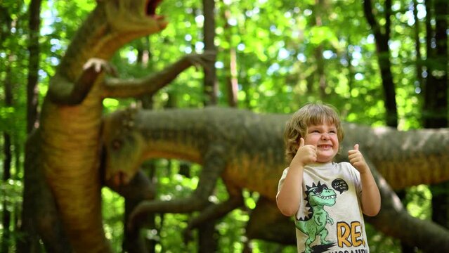 Little boy watching Exhibition of models of sculpture dinosaur in Dinopark