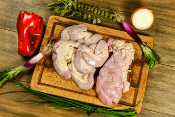 Cow bowels presented on a wooden board with ingredients, ready to grill