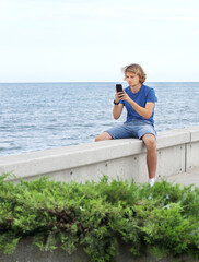 young man walking along the promenade and taking pictures