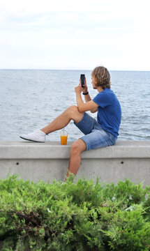 young man walking along the promenade and taking pictures