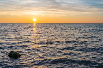 Fototapeta na wymiar traumhafter, oranger, Sonnenuntergang zwischen Felsen im Meer der Ostsee bei Dranske auf Rügen 
