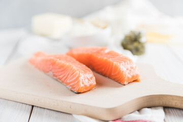 Salmon pieces on wooden cutting board