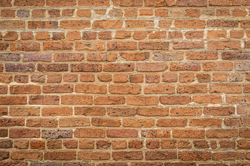 A blank red brick wall that is heavily weathered with plenty of copy space