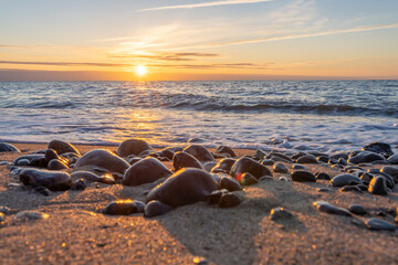 Obraz premium traumhafter, oranger, Sonnenuntergang zwischen Felsen im Meer der Ostsee bei Dranske auf Rügen 