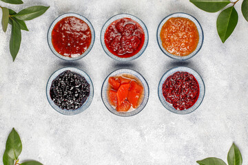 Assortment of summer seasonal berry and fruits jams in small jars, homemade preserving concept, marmalades or confitures with fresh berries jam jar, mix jam, various jams, type jam, different jams. - Powered by Adobe