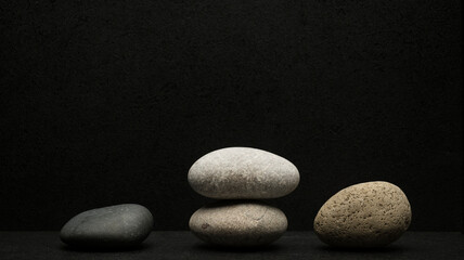 Fototapeta na wymiar gray zen stones on dark background for podium background