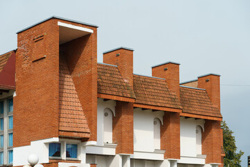 Details of construction of the roof the building of the last century. An unusual architectural solution, unusual shapes of the red brick roof. Abstract structure background.