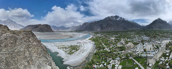 A 180-degree aerial panorama of Skardu Valley, Indus River delta, and Kharpocho Fort located on a...