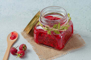 Jar of raspberry jam on marble background from top view, Fresh homemade raspberry jam in glass, Sweet homemade raspberry jam in small glass jar on wooden background, with fresh berries copy space.