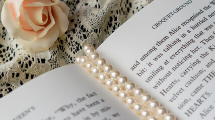 Fototapeta na wymiar Flowers, foreign books and necklaces (image of a soft and cute reading lifestyle)