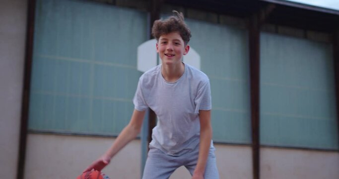 Father teaching his teen son how to attack and defend in basketball. People playing street basketball during a warm summer day. Two playing a basketball match on an outdoors court during