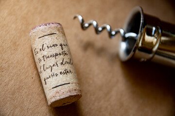 Destapador y corcho de una botella con texto, fondo madera