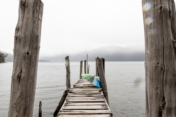 Paraguas de colores en un muelle en un día con lluvia y neblina. Fotografía tomada con filtro y baja velocidad para efecto sedado