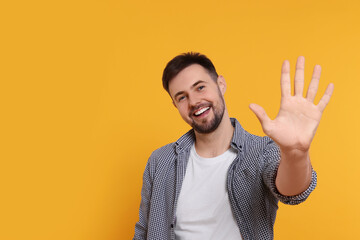 Man giving high five on yellow background. Space for text