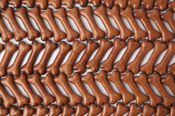 Flat lay composition with many bone shaped dog cookies on white background