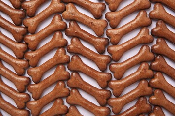 Flat lay composition with many bone shaped dog cookies on white background