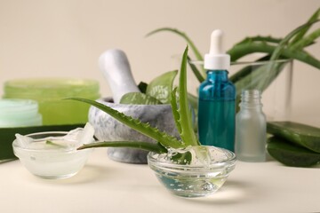 Bowl with natural gel and fresh aloe on beige background