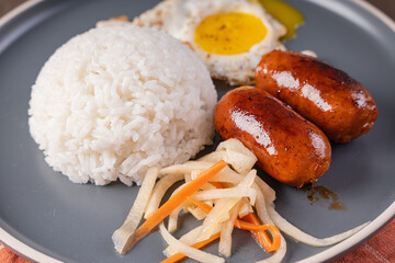 a delicious breakfast that is very common among Filipinos, longanisa in garlic rice with fried egg and pickled papaya