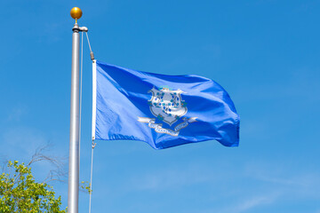 Flag of Connecticut against blue sky in village of Mystic, Stonington, Connecticut CT, USA. 