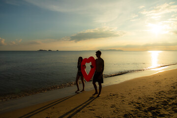 silhouette couple in love on summer beach sunset. Happy romantic couple enjoying and relaxing on the Beach