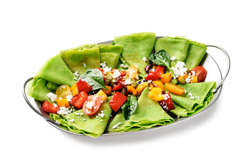 Fresh prepared delicious green spinach crepes served with colorful baked peppers and cherry tomatoes. isolated on white background